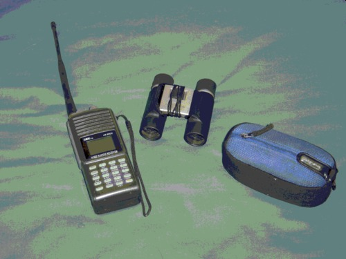 A pair of binoculars, a radio scanner and a small digital camera