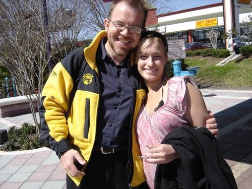 Niel Malan wearing a fleece jacket hugging a young woman in short sleeves